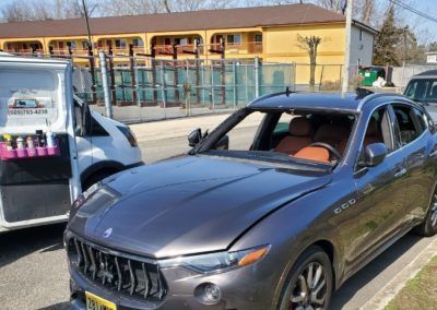 A gray car is parked next to a white van.