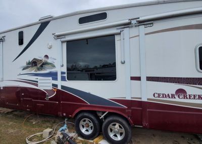 A cedar creek trailer is parked in the grass
