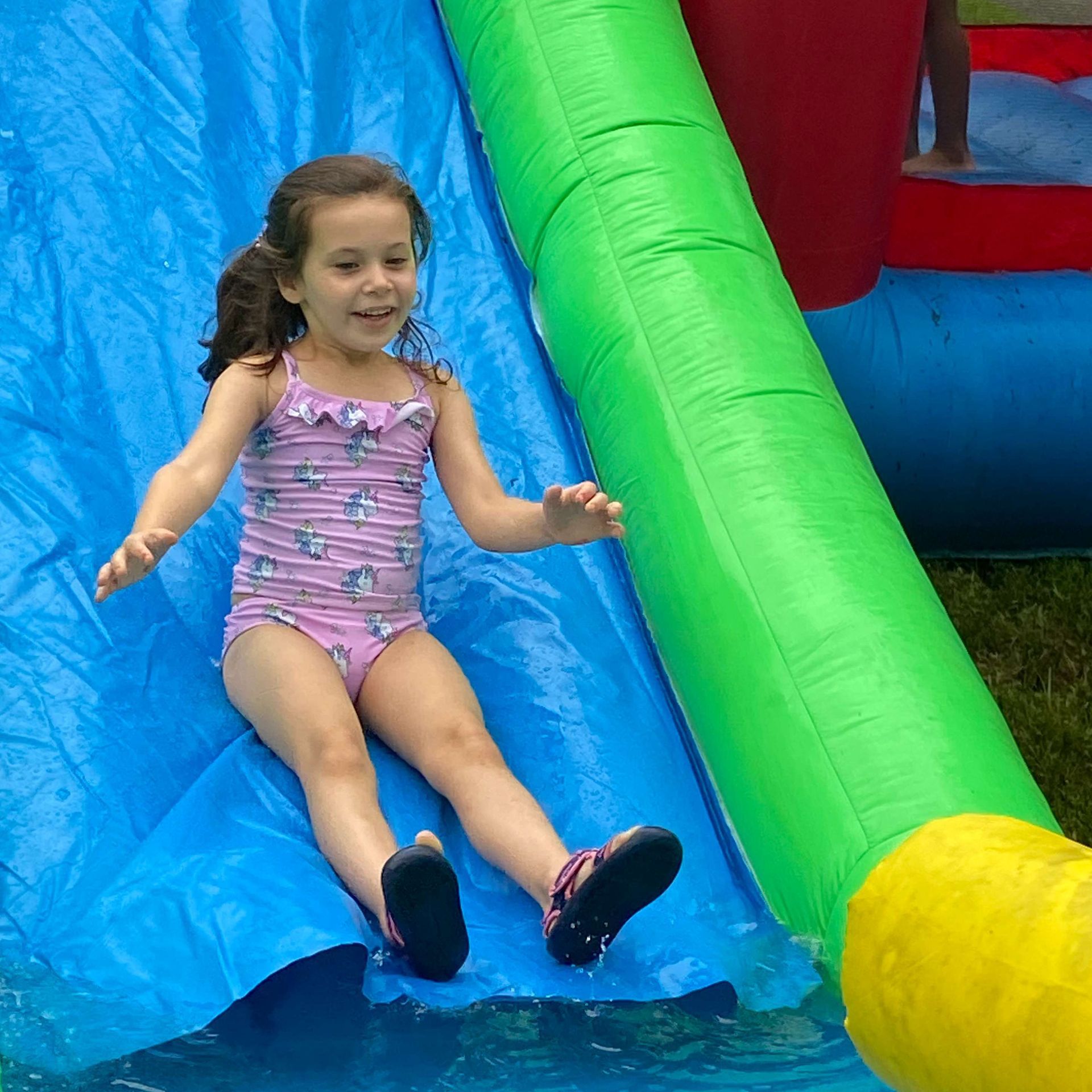 A young girl sliding on a inflatable slide