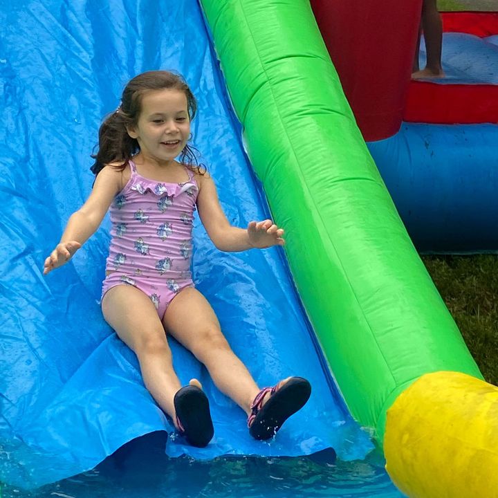 A Kid Sliding on a Pool Slide