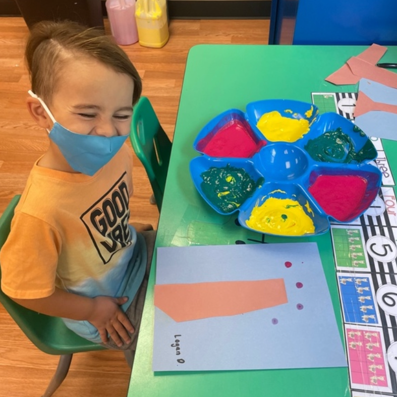 A young boy wearing a mask and a shirt that says good job