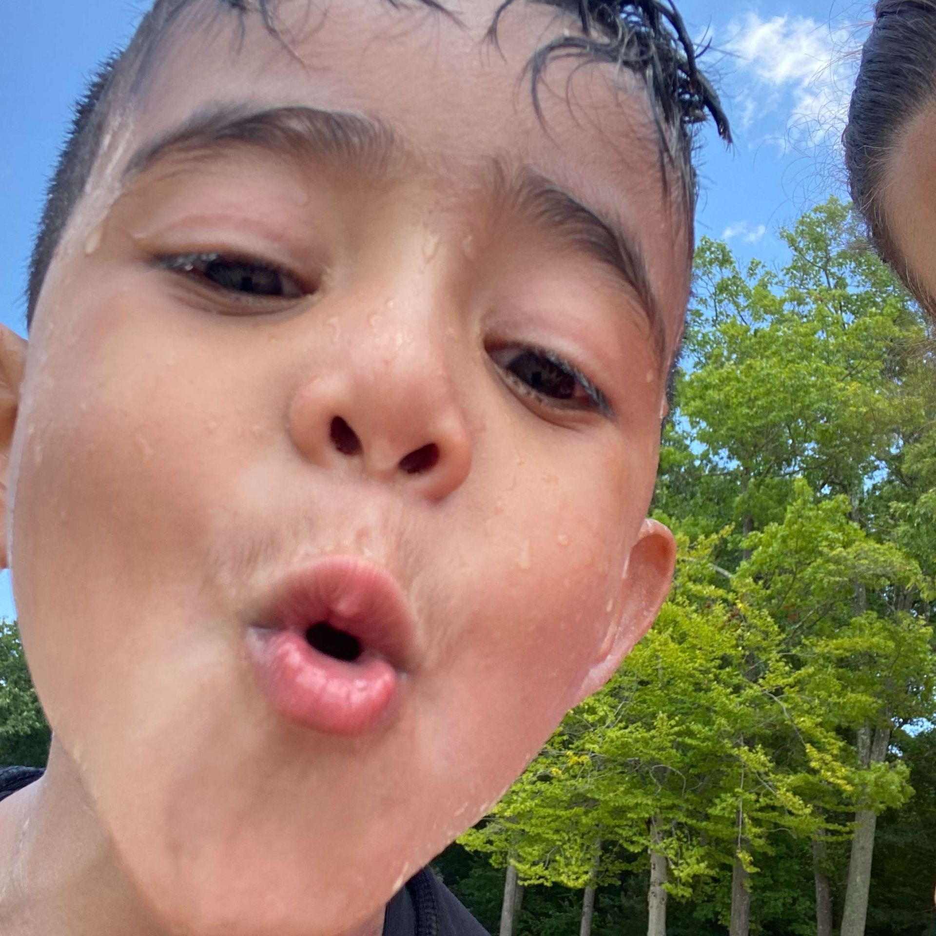 A close up of a young boy 's face with his mouth open.