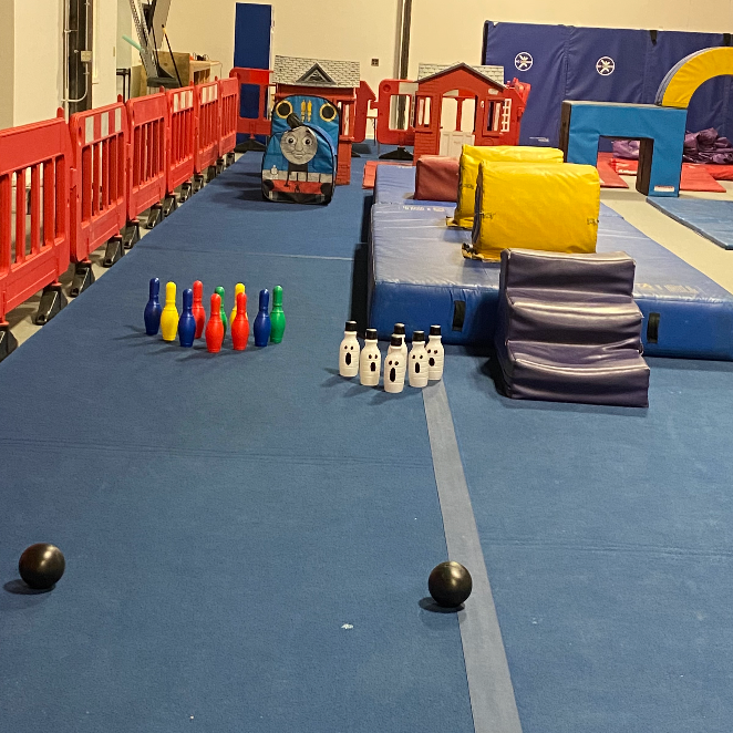 A bowling alley with a thomas train in the background
