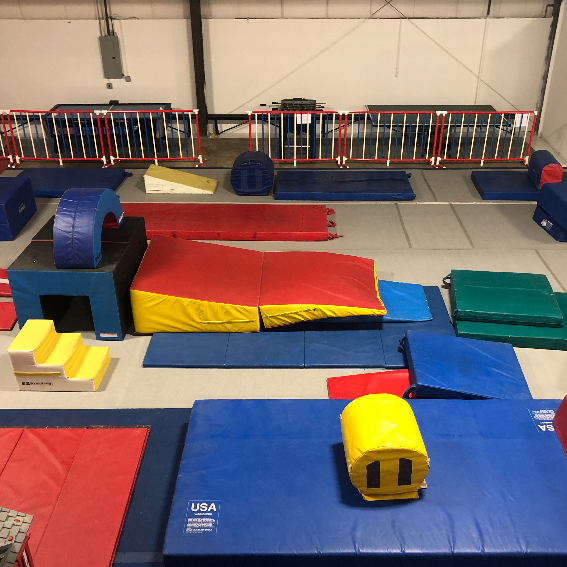 A gym filled with a bunch of mats and a yellow block with the number 11 on it