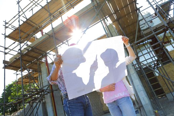 un uomo e una donna sono in piedi davanti a un cantiere edile