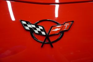 Close-up of a red Corvette emblem with black-and-white checkered flag and red flag badges