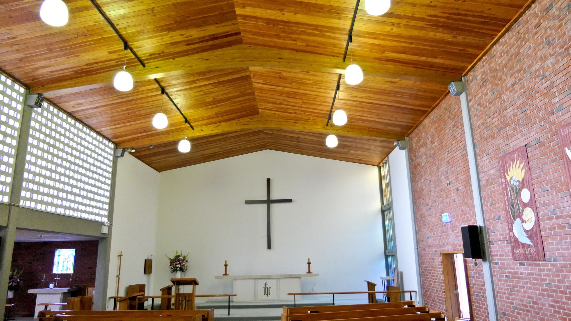 A church with a wooden ceiling and a cross on the wall