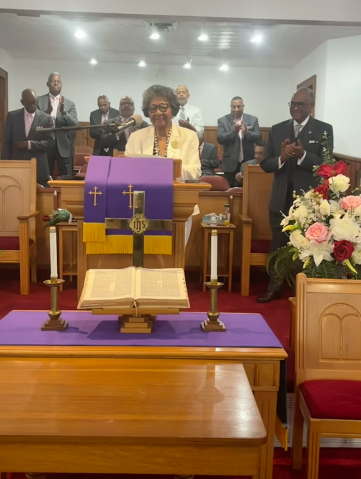 A man and a woman are standing next to a podium in a room.
