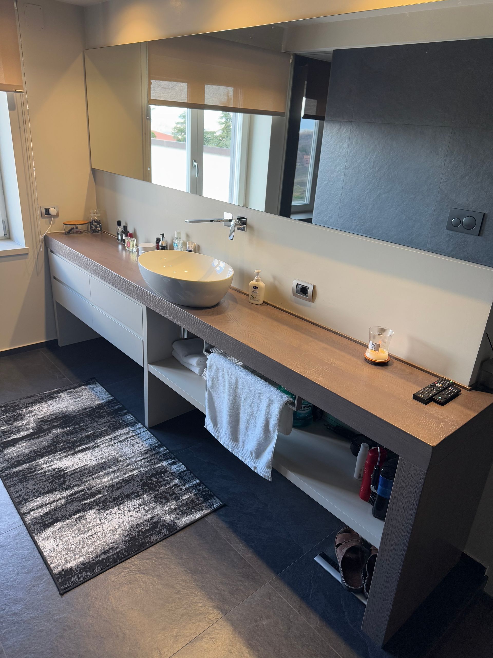 Uomo che si muove su un pavimento con motivi geometrici tridimensionali grigi.