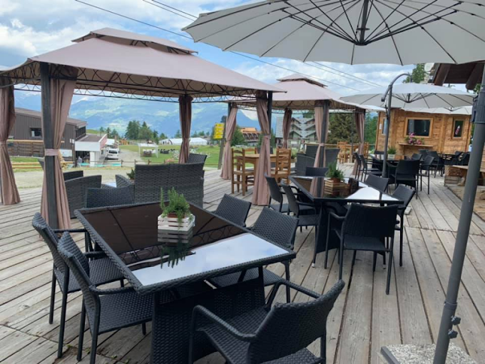 Un ponte di legno con tavoli e sedie sotto gli ombrelloni