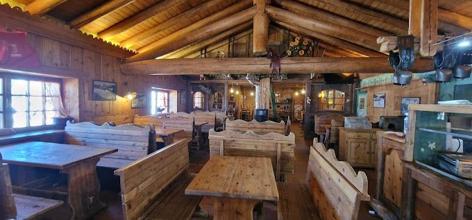 Un ristorante pieno di tavoli e panche di legno.