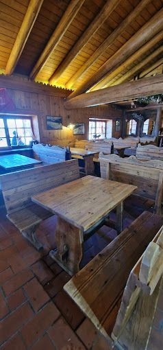 Una fila di tavoli e panche di legno in un ristorante.