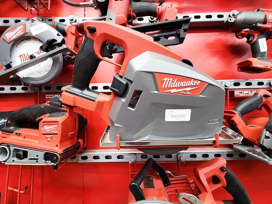 a milwaukee circular saw is sitting on top of a shelf with other tools .