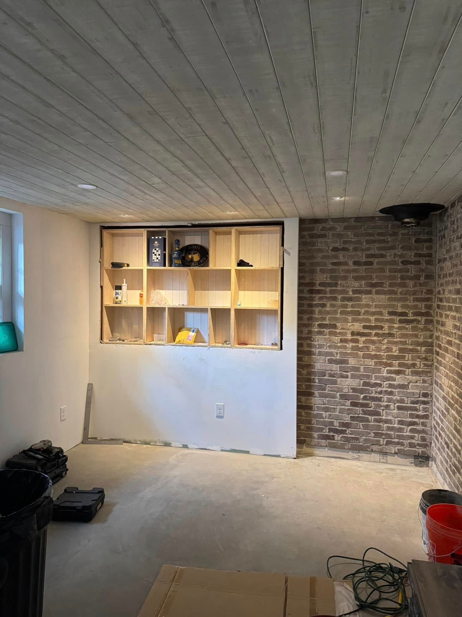 A room with a brick wall and shelves in it.
