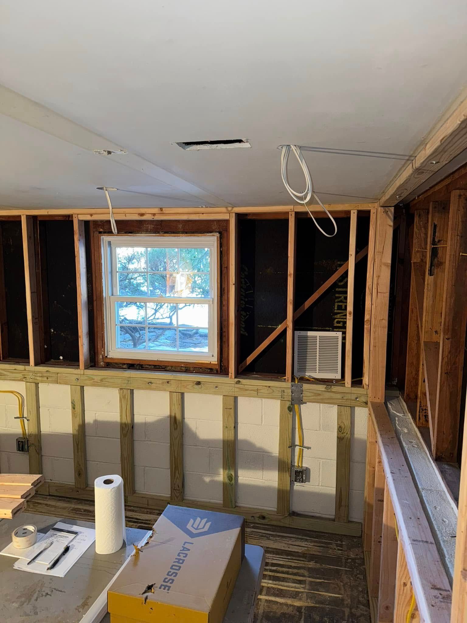 A room under construction with a window and a box on the floor.