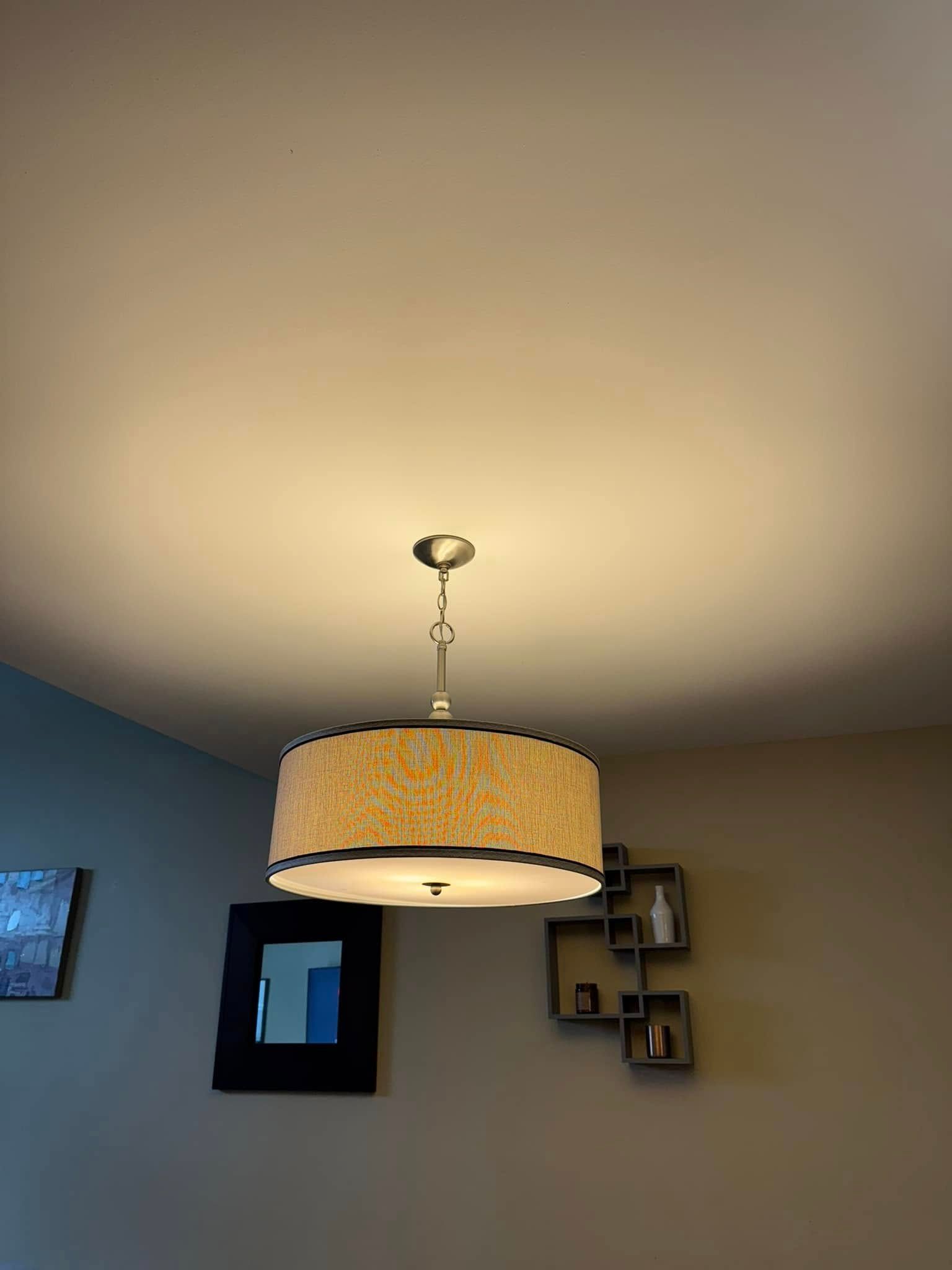 A light fixture is hanging from the ceiling in a living room.