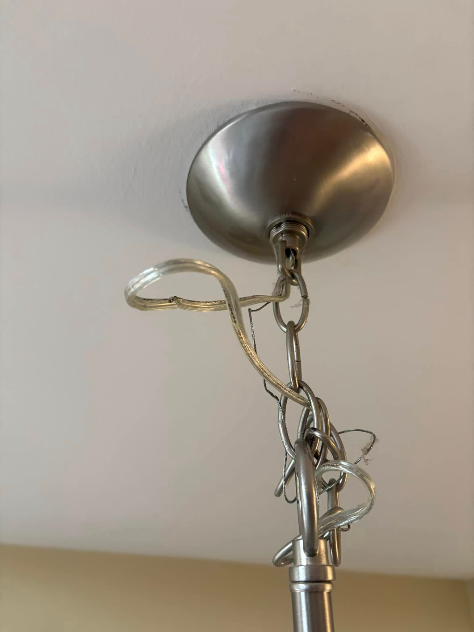 A close up of a ceiling light with a chain hanging from it.