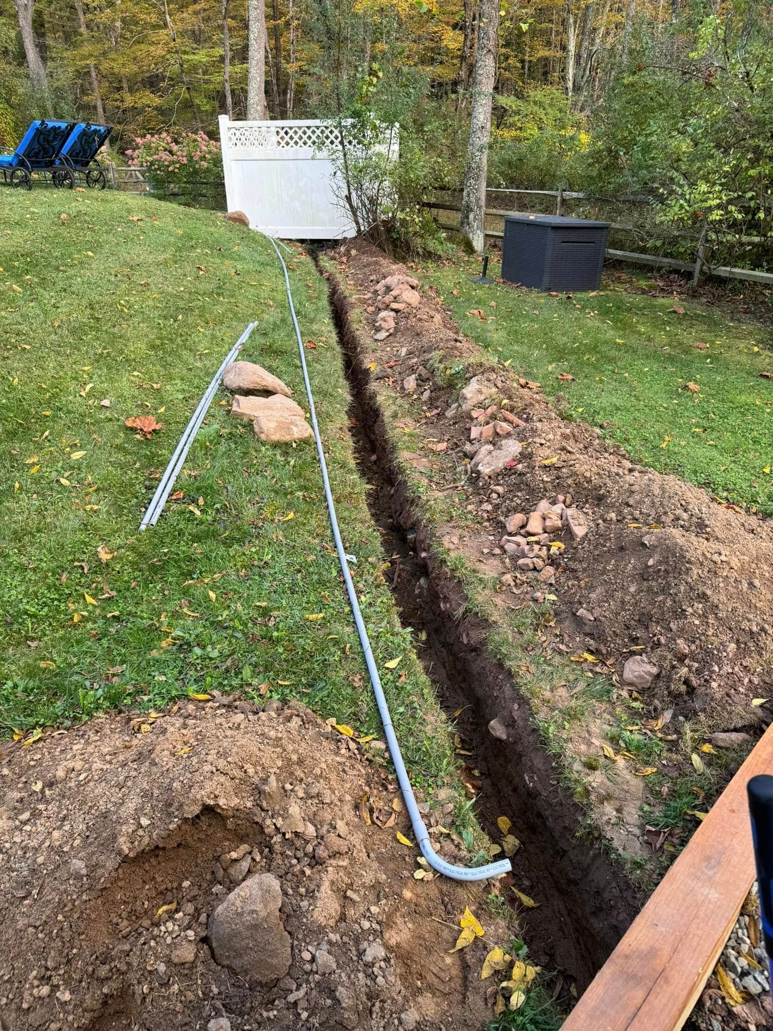 A person is digging a hole in the ground in a yard.