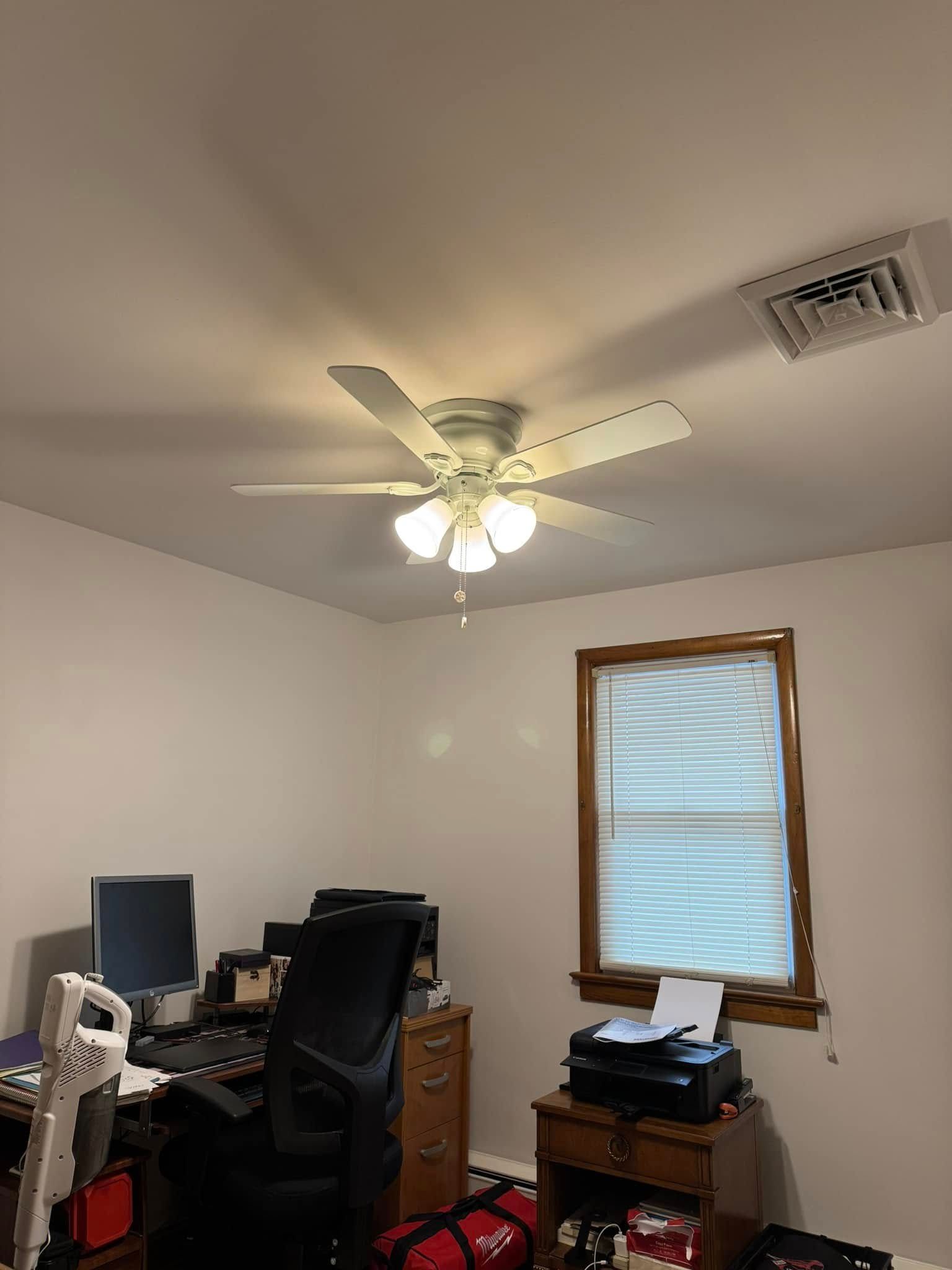 There is a ceiling fan in the corner of the room.