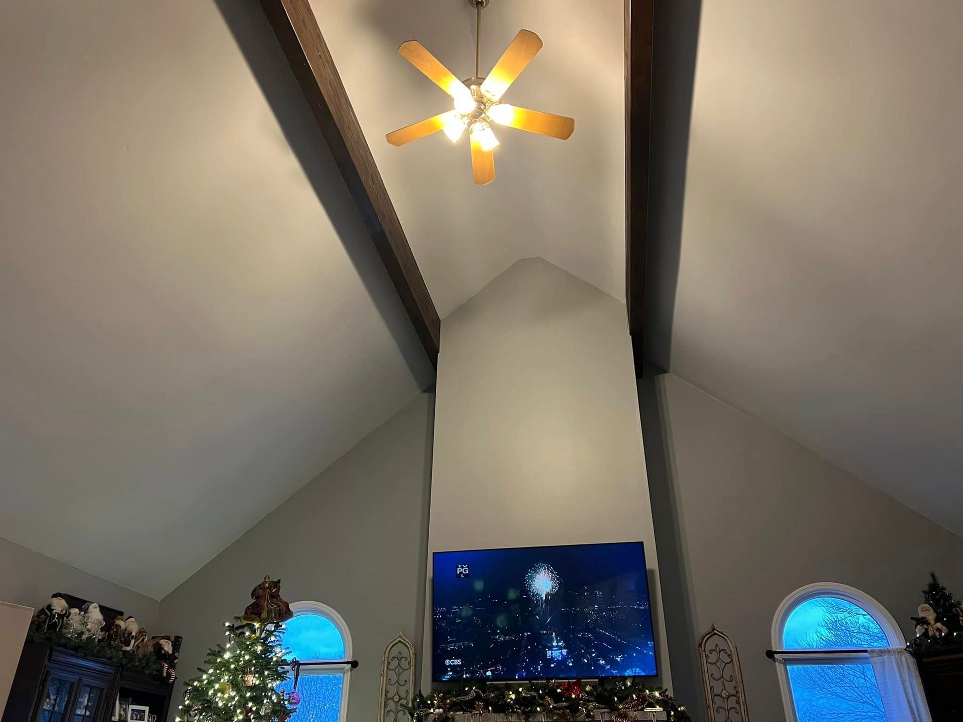 A living room with a ceiling fan and a christmas tree.
