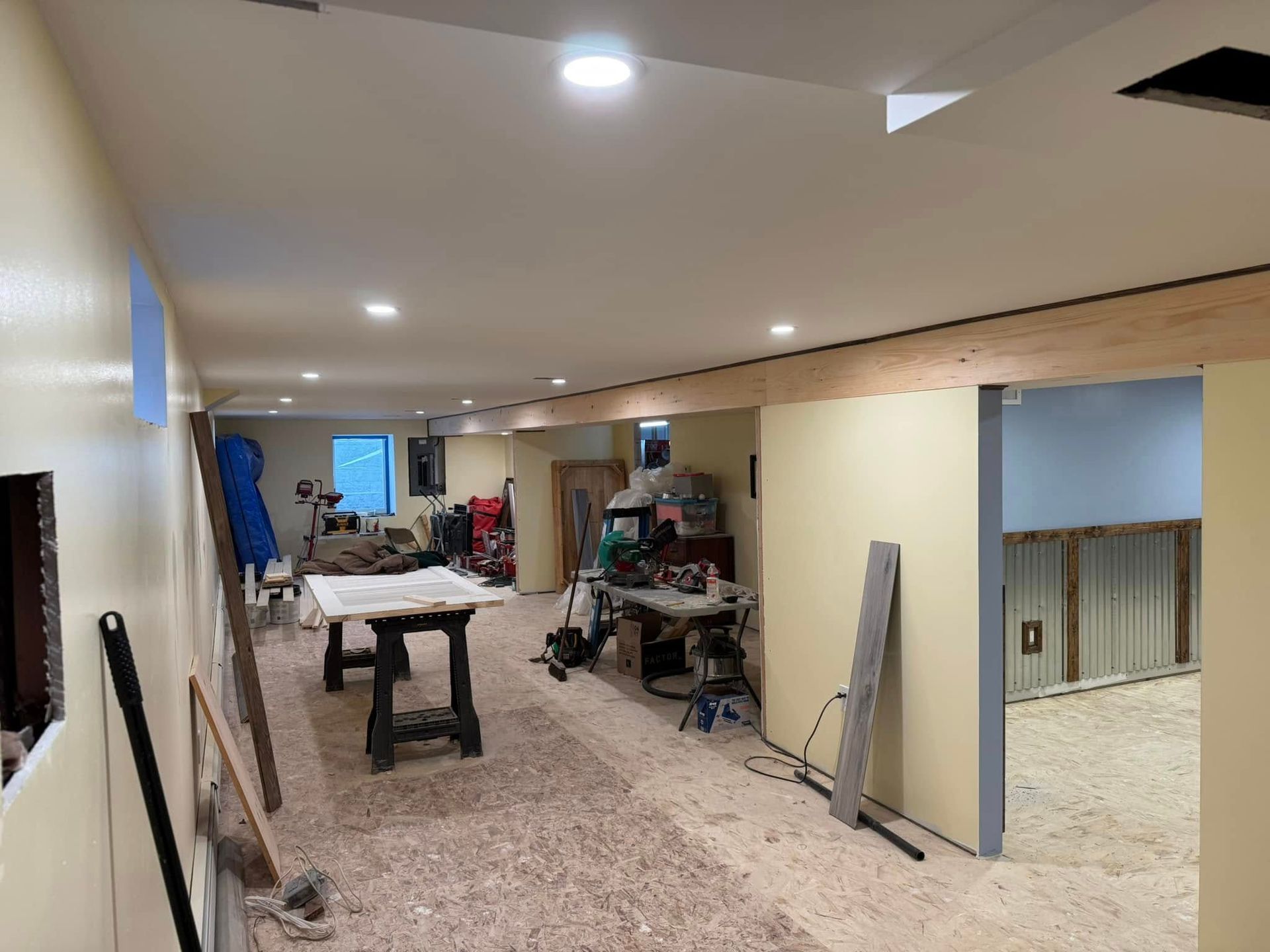 A basement under construction with a table and a table saw.