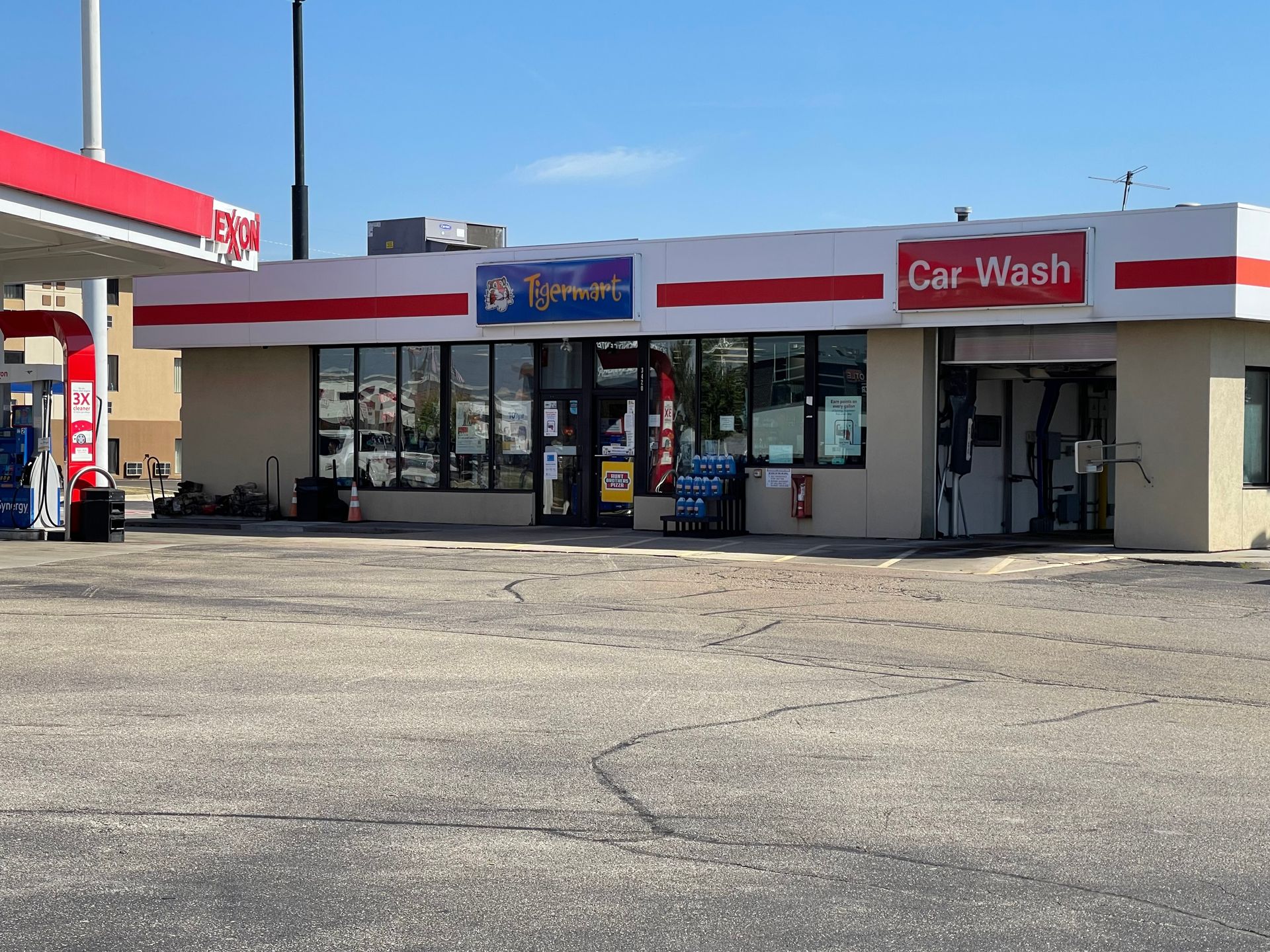 Gas station with convenience store and car wash under blue sky.