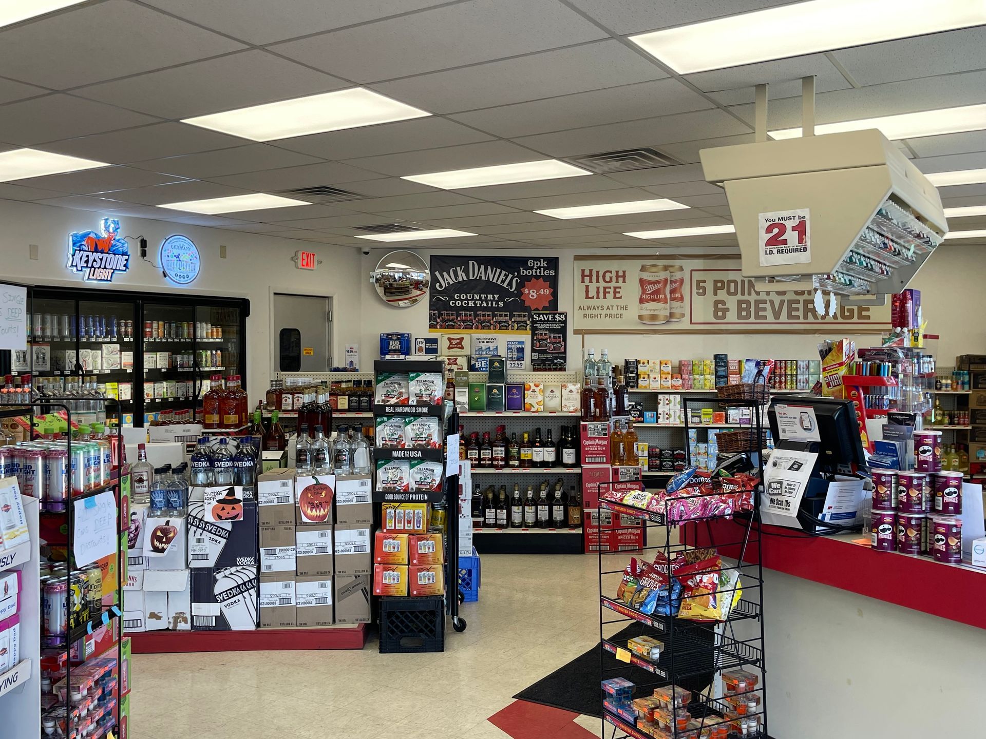 Interior of a convenience store, stocked shelves, snacks, drinks, and a cash register.