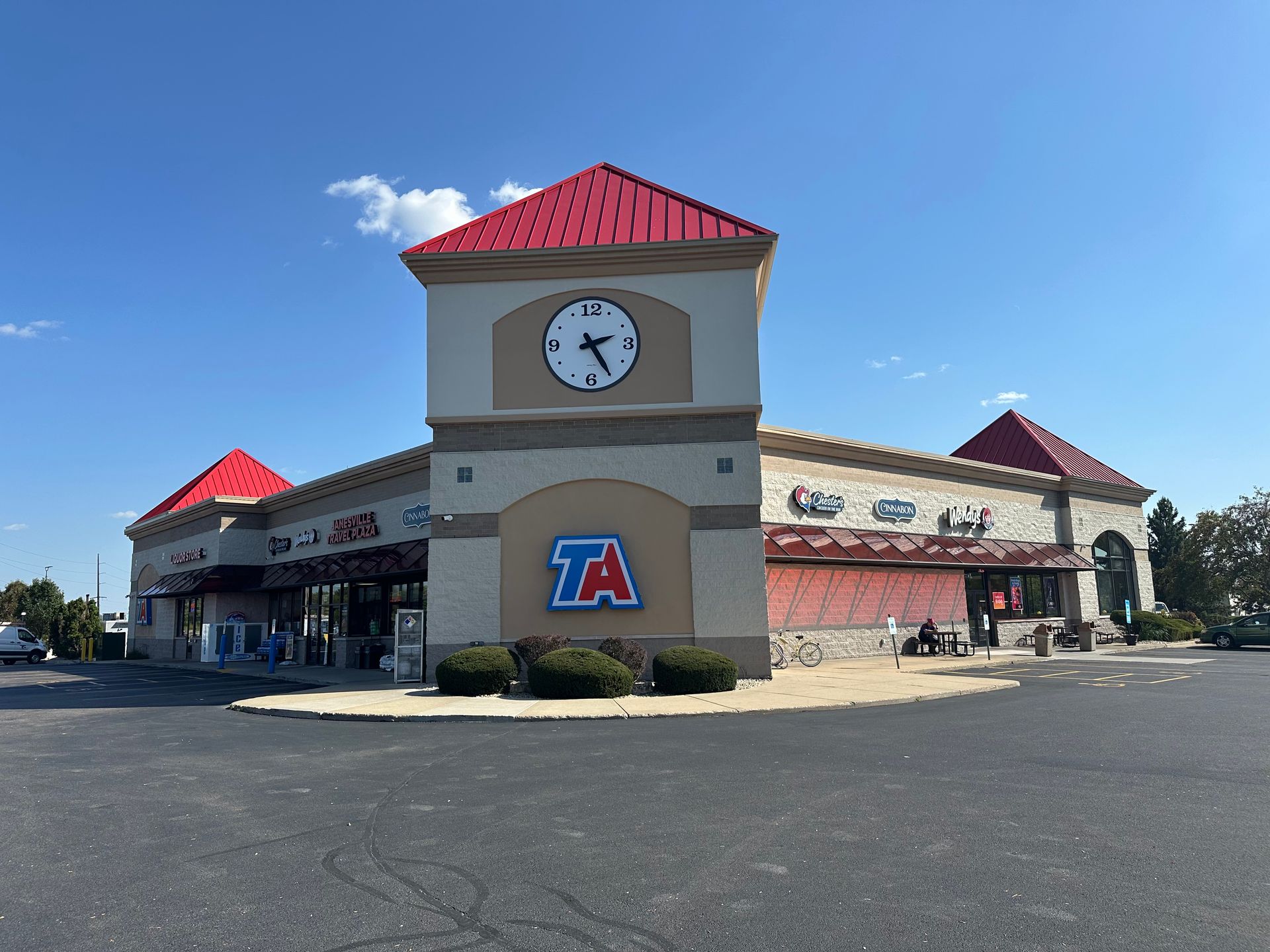TA travel center building with clock tower and red roofs on a sunny day.