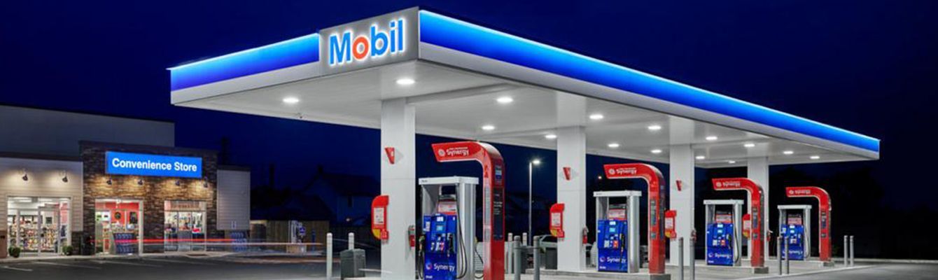Mobil gas station at night with blue and white canopy and convenience store.
