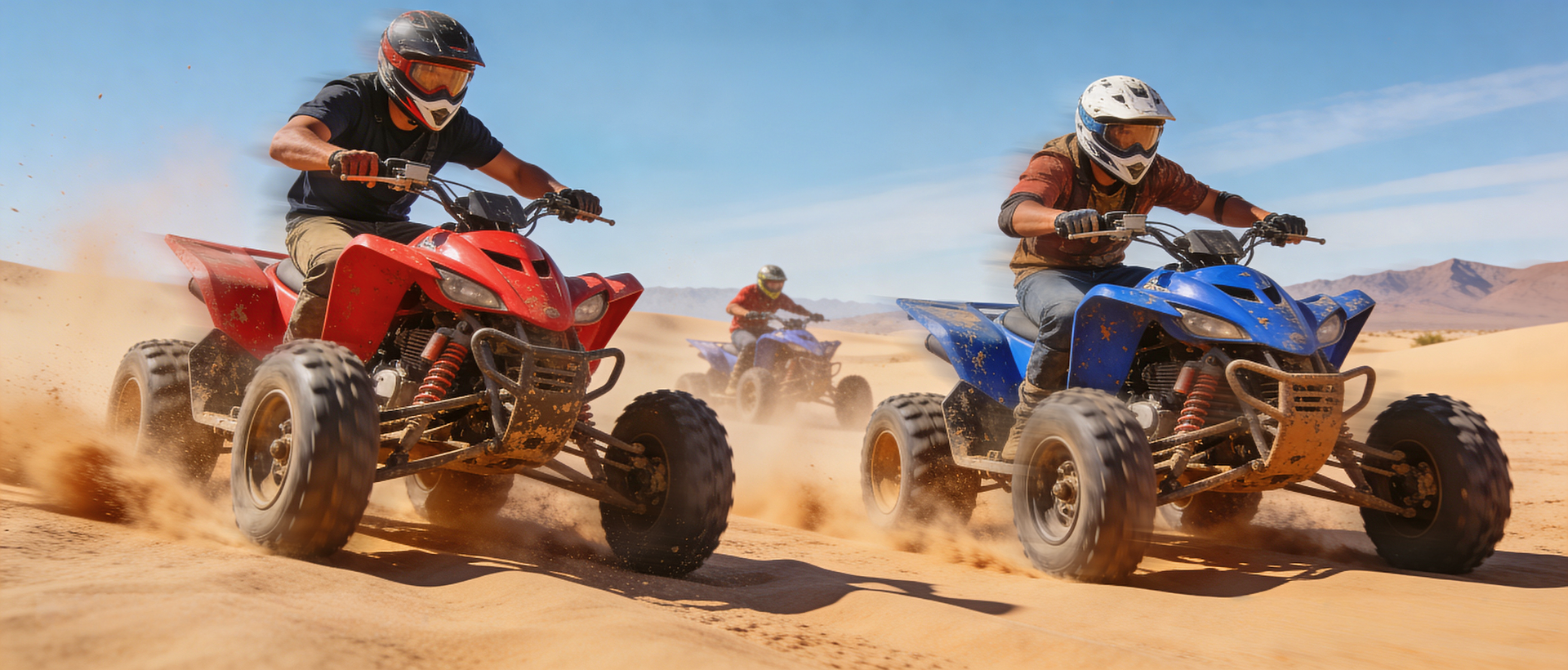 Three people ride ATVs across a sunny sand dune landscape, kicking up dust as they move forward.