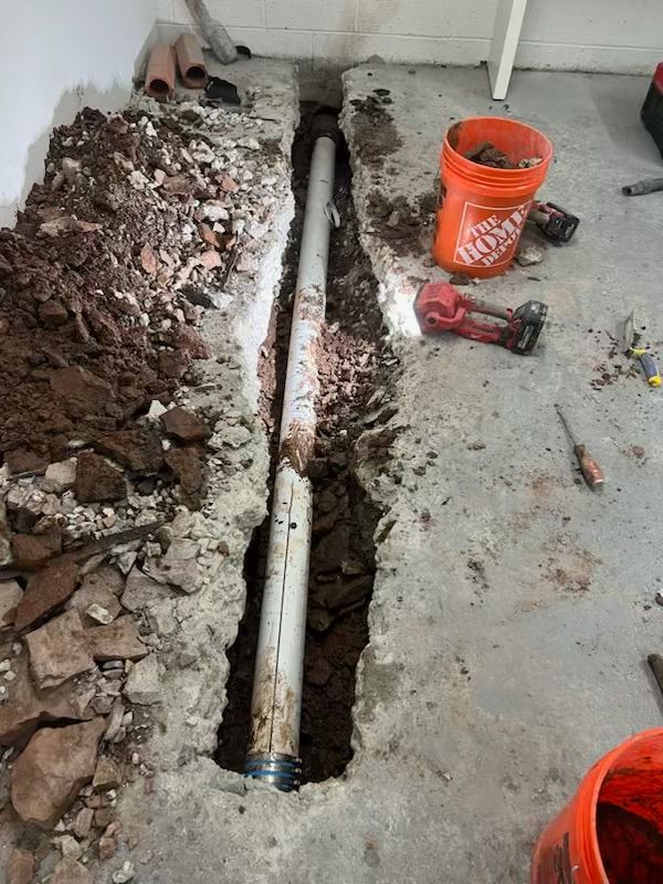 A pipe is being installed in a hole in the floor.