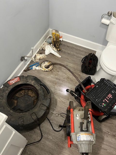 A bathroom with a toilet and a tire on the floor