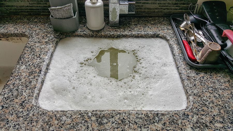 A bathroom sink with a t on the bottom of it