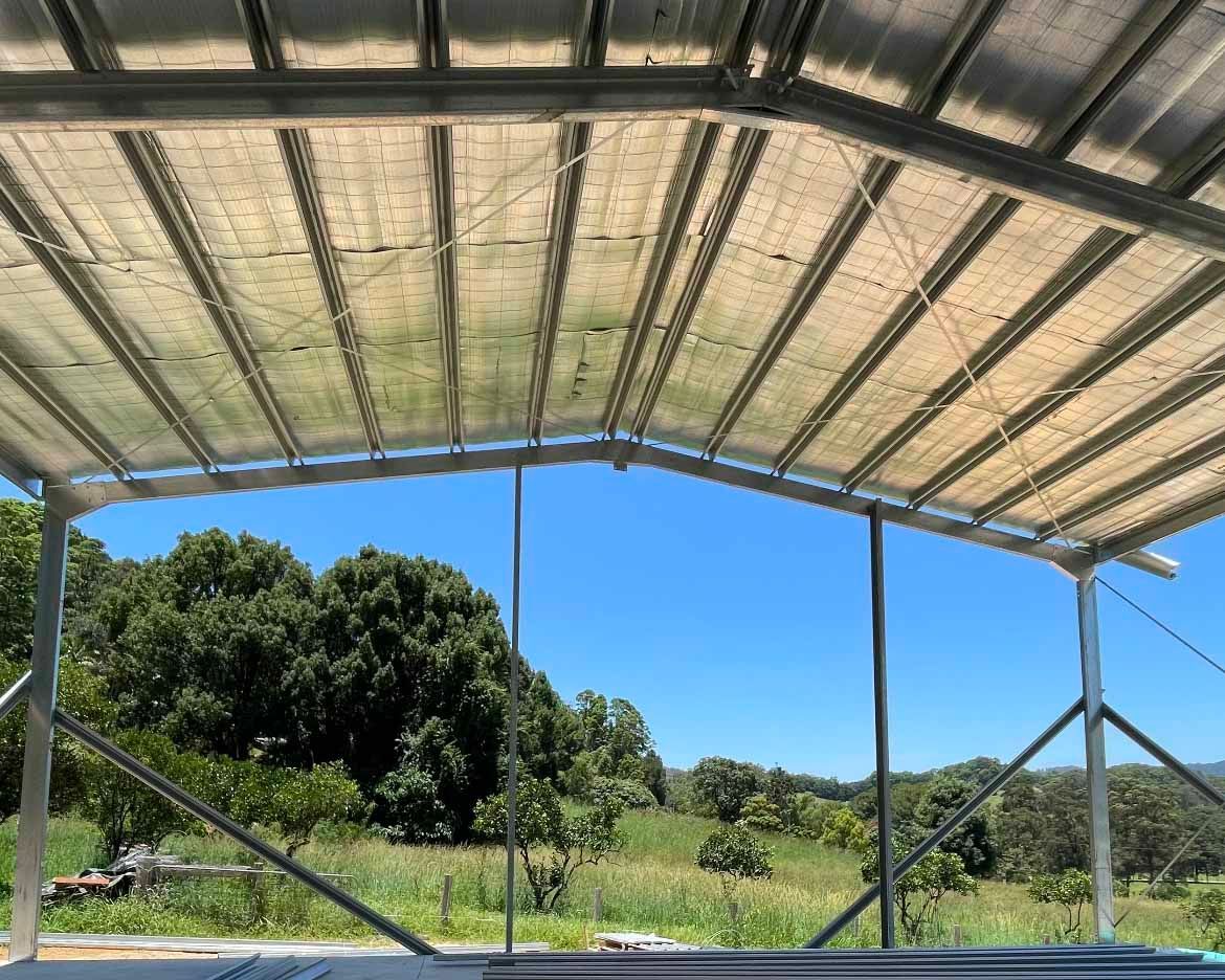 Roof of a building with trees in the background — Providing Steel & Concrete Construction In Byron Bay, NSW