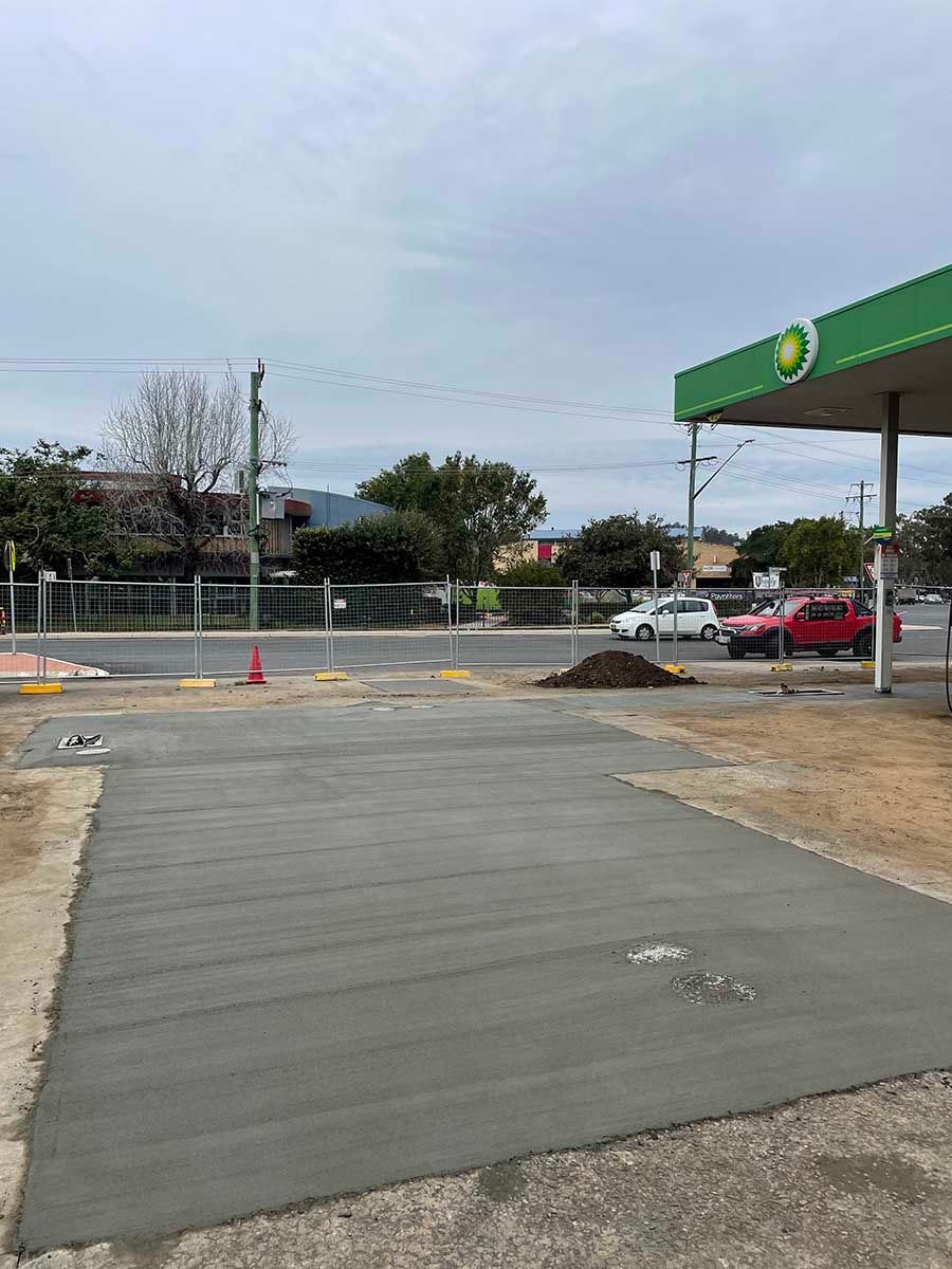 Concrete Driveway Is Being Built In Front Of A BP Gas Station — Providing Steel & Concrete Construction In Lismore, NSW