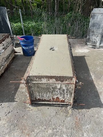 Concrete Box Is Sitting On The Ground Next To A Blue Bucket — Providing Steel & Concrete Construction In Byron Bay, NSW