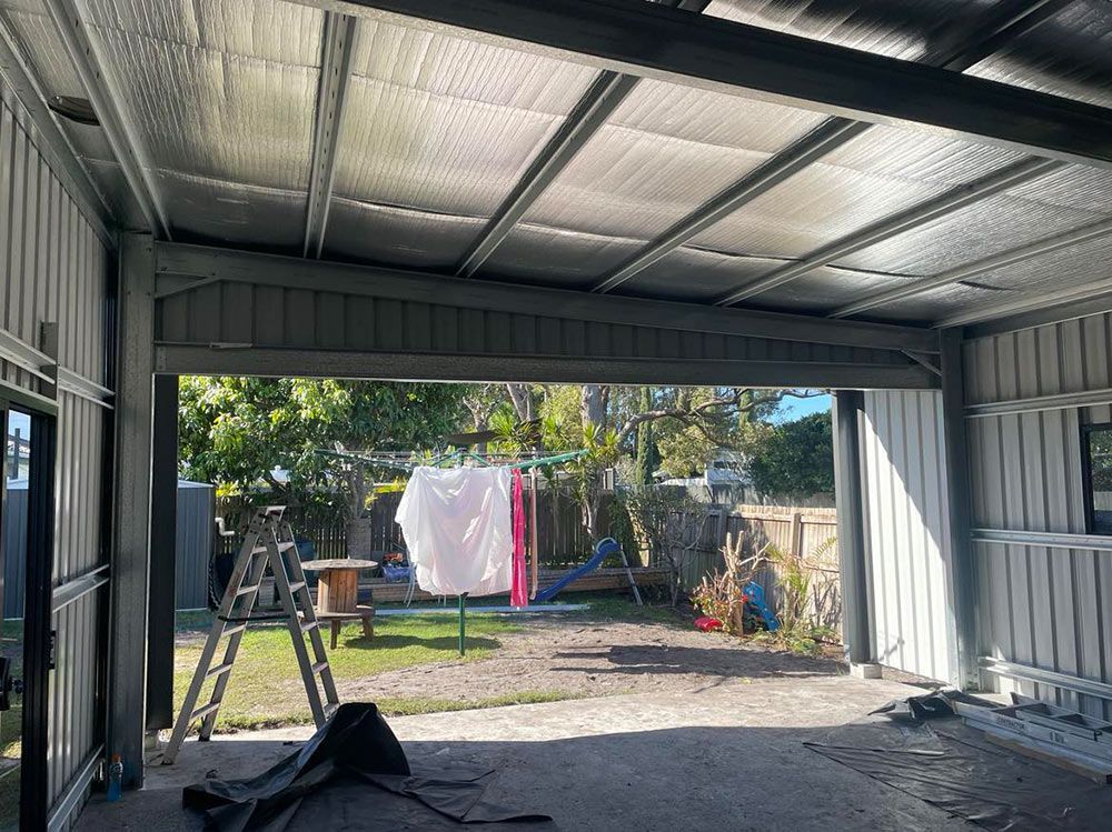 A Garage With A Ladder And Clothes Hanging On A Clothes Line— CJR Group Concrete Construction In Byron Bay, NSW