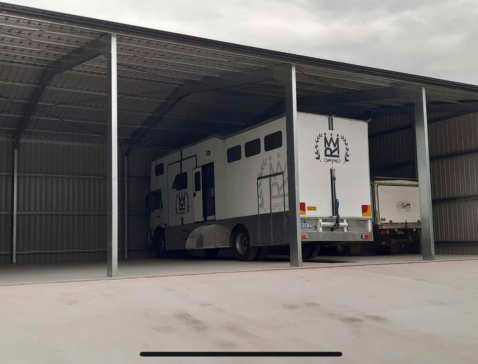White Truck Is Parked Under A Covered Shed — Providing Steel & Concrete Construction In Eviron, NSW