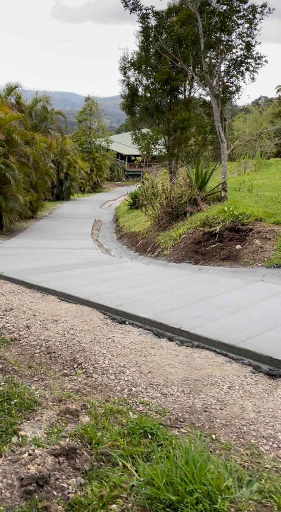 Concrete Driveway Going Up A Hill With A House In The Background — Providing Steel & Concrete Construction In Eviron, NSW