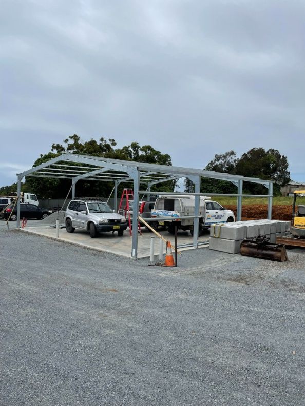Car Parked Under a Metal Structure in a Parking Lot — Providing Steel & Concrete Construction in Eviron, NSW