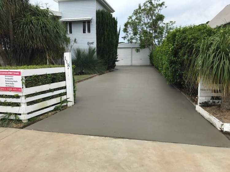 Concrete Driveway Leading To A House With A White Fence - Providing Steel & Concrete Construction In Byron Bay, NSW