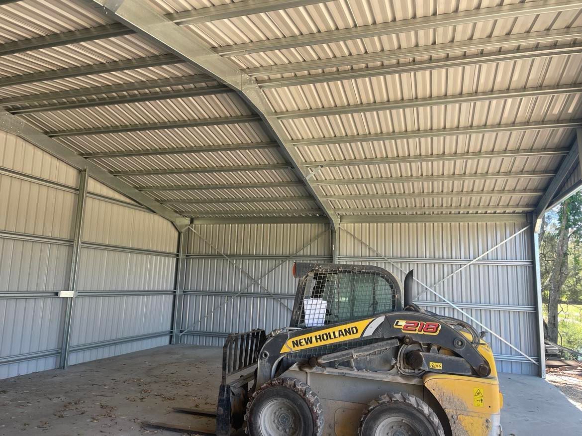 Bulldozer Parked Inside Of A Metal Building — Providing Steel & Concrete Construction In Eviron, NSW