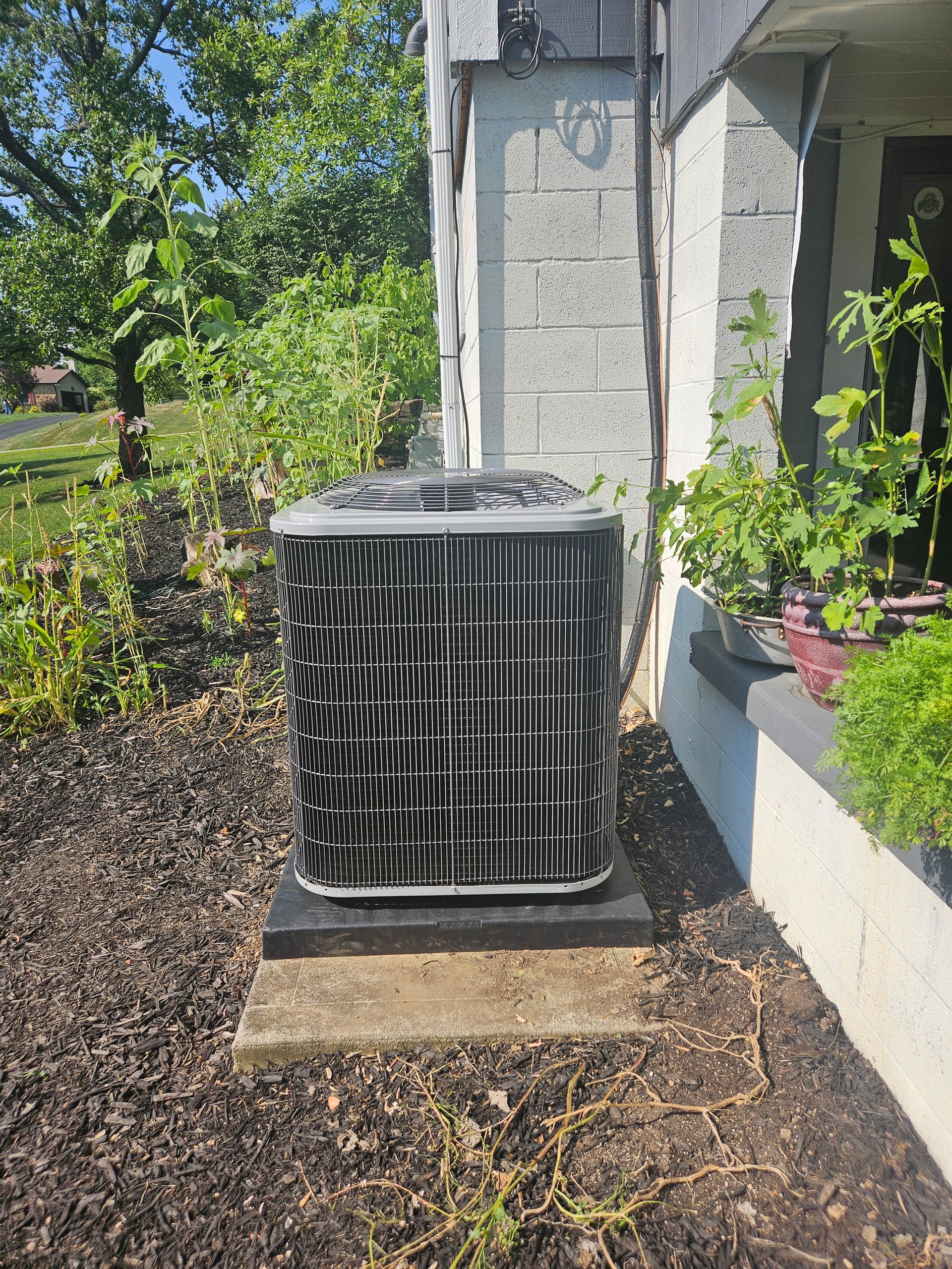 An air conditioner is sitting on the side of a building.