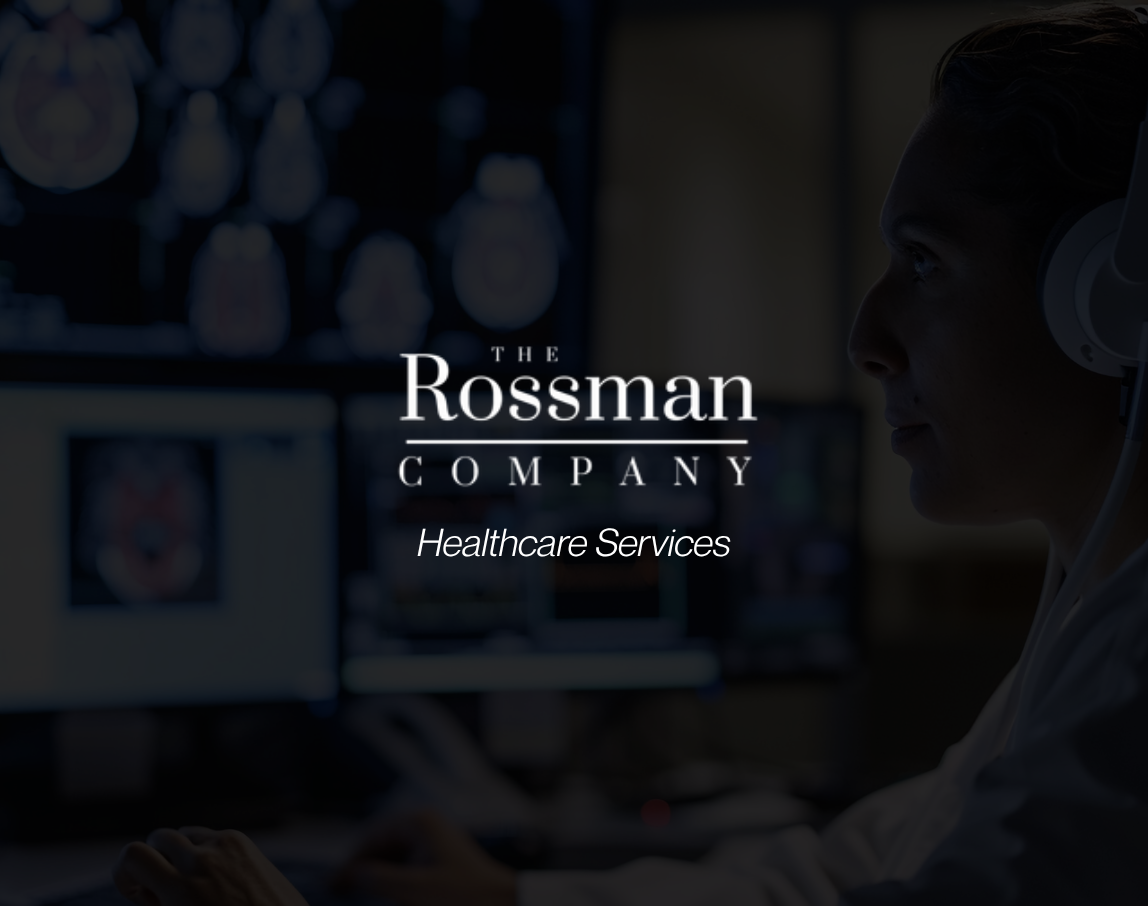 A woman wearing headphones is working on a computer with the rossman company logo in the background