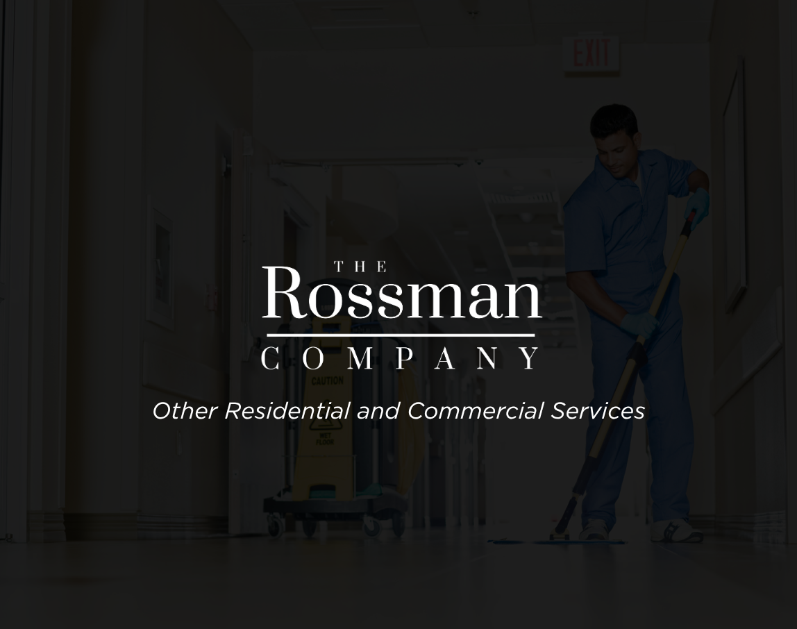 A woman wearing headphones is working on a computer with the rossman company logo in the background