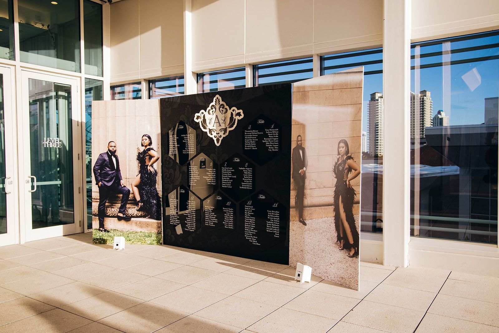 a group of people standing in front of a building with a large black wall .