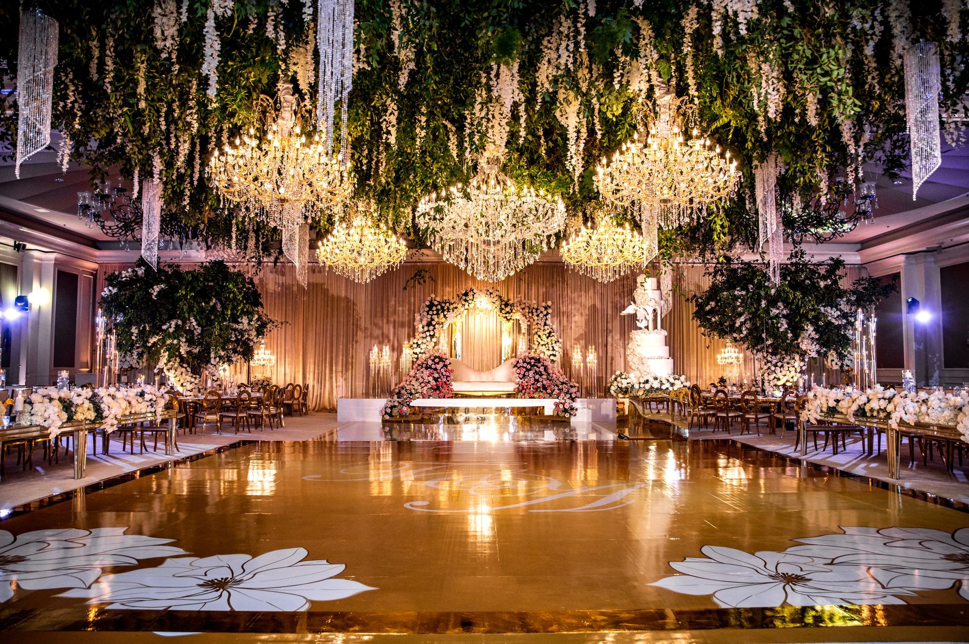 a large room with a dance floor and chandeliers hanging from the ceiling .