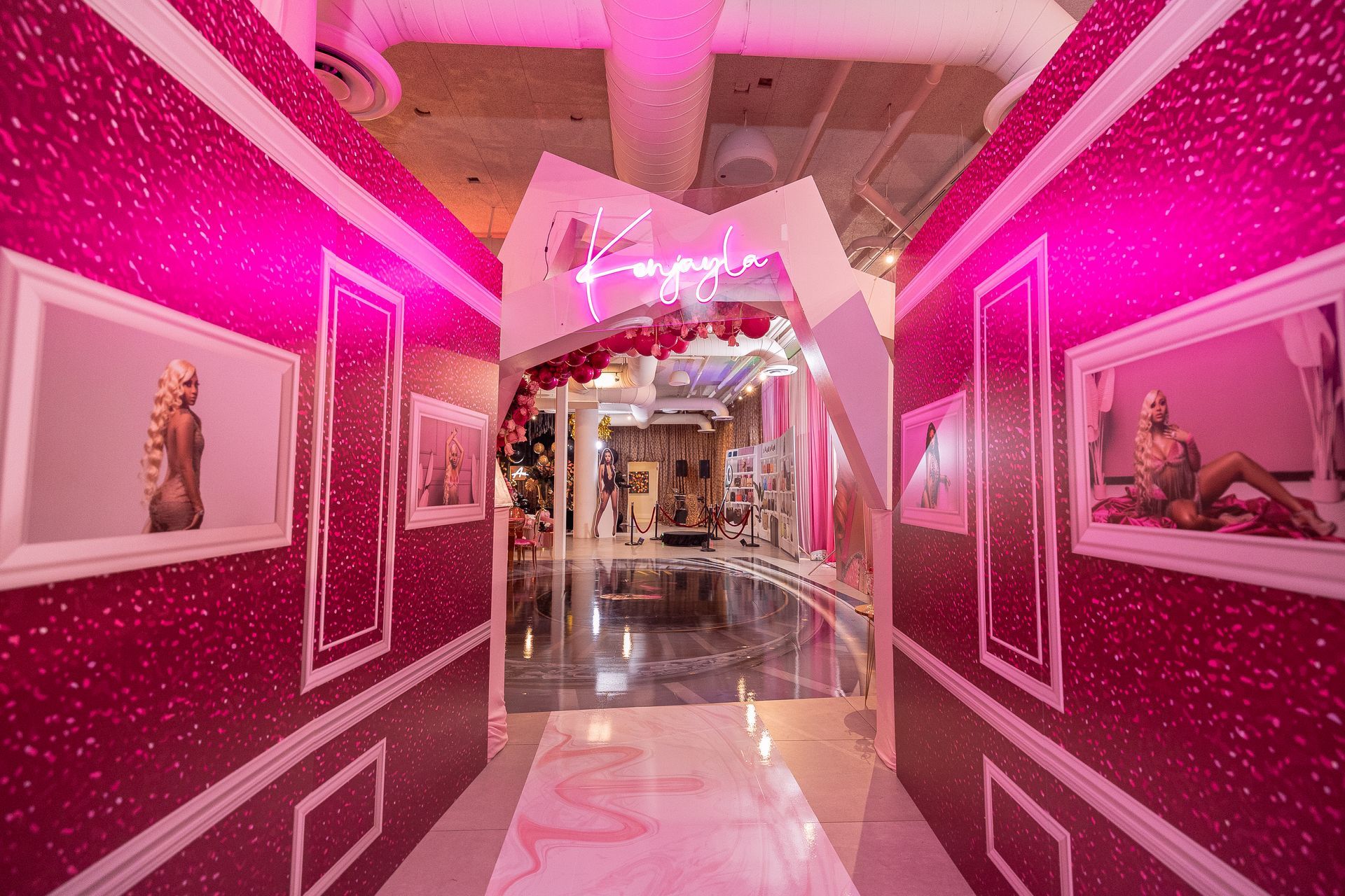 a hallway with pink walls and pictures on the wall .