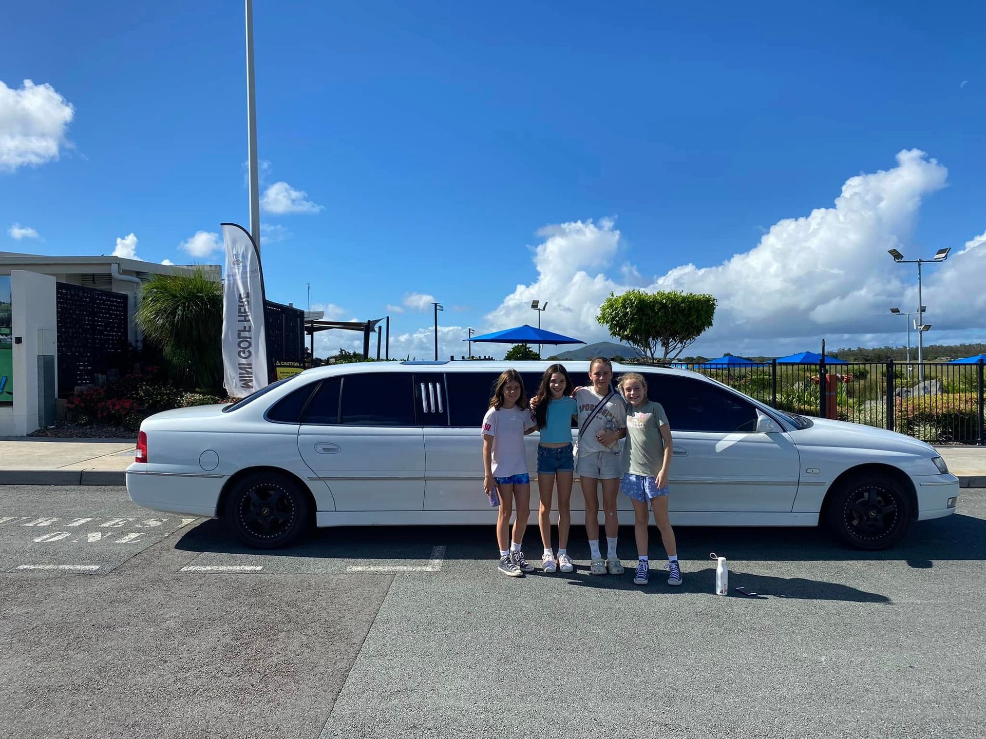 A Group of People Are Posing for a Picture in a Limousine — Noosa Premier Stretch Holden Transfers In Sunrise Beach, QLD