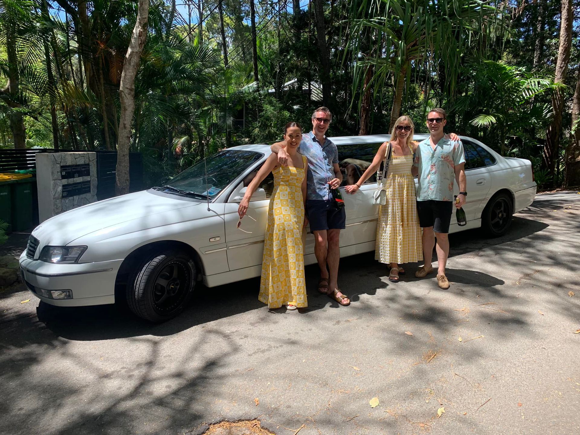 A Group of People Are Standing in Front of a White Car — Noosa Premier Stretch Holden Transfers In Sunrise Beach, QLD